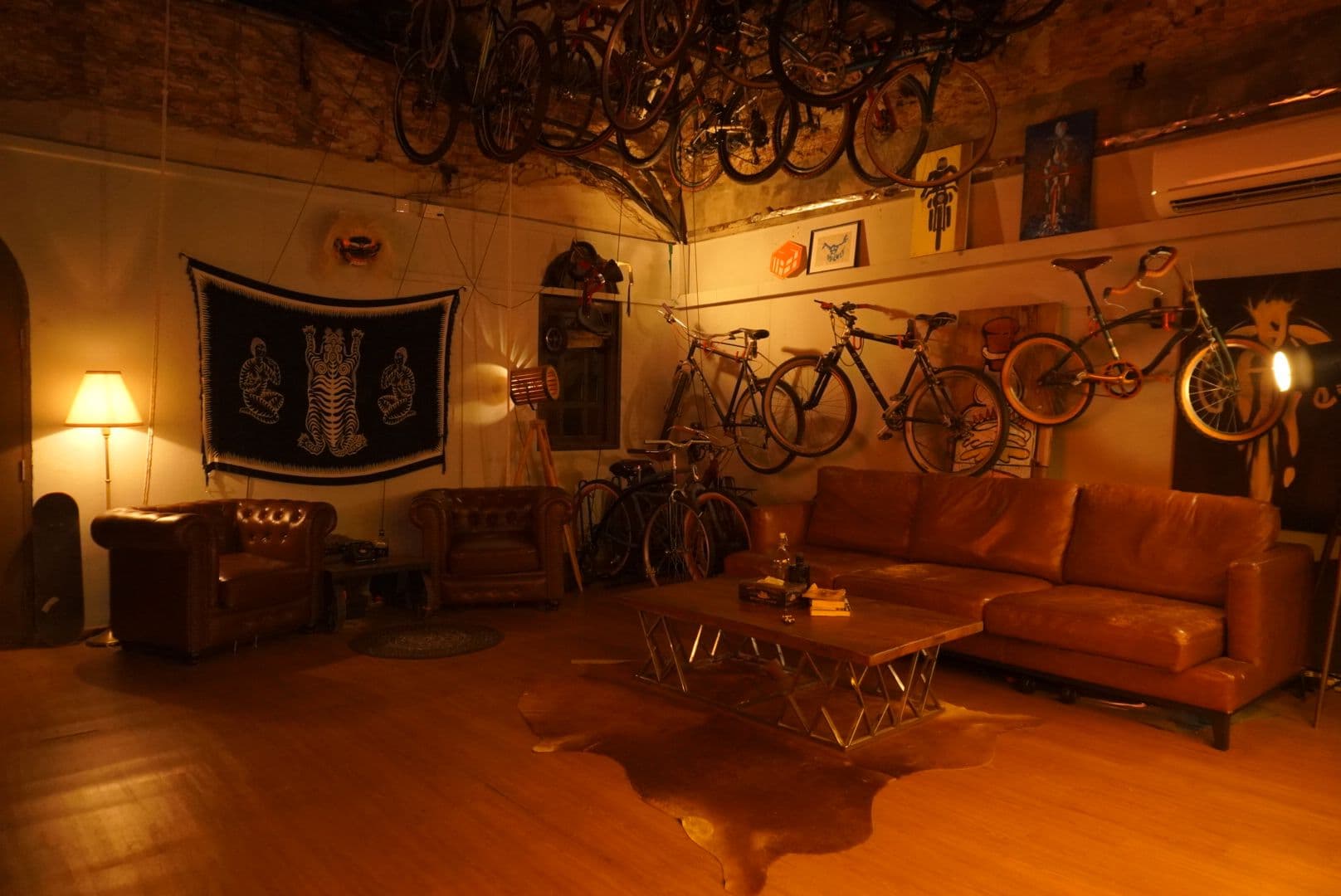 Leather chesterfield lounge and bikes hung from the ceiling at Cult Commons Singapore